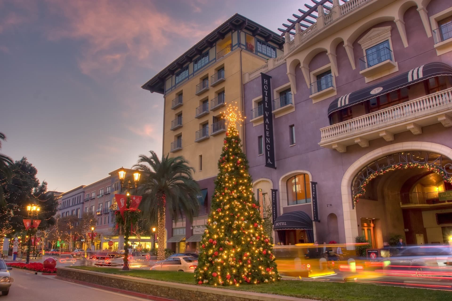 Hotel entrance with Christmas tree and holiday lights at dusk