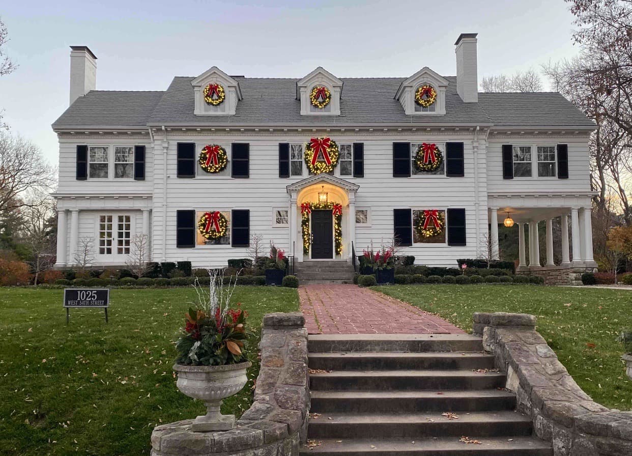 Colonial home front with Christmas wreaths and roofline lights