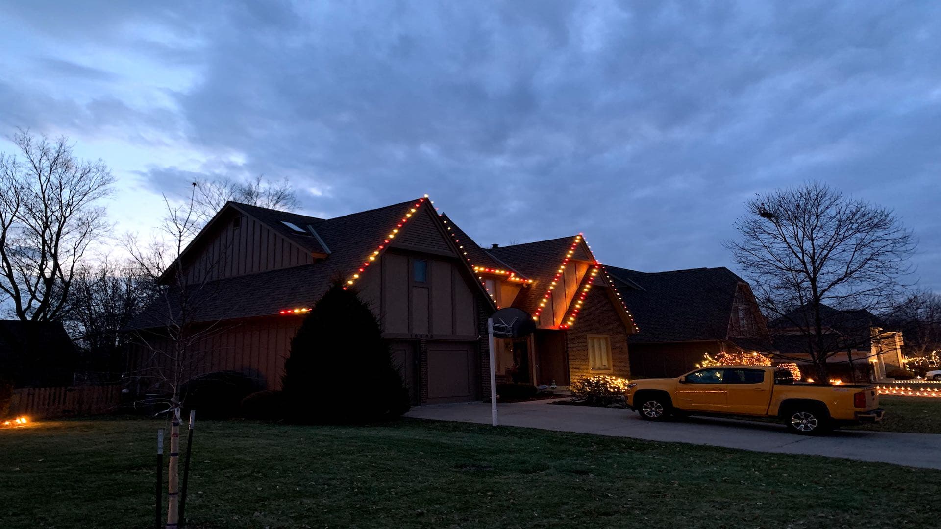 Tudor style home with multicolor Christmas lights at dusk in Kansas City