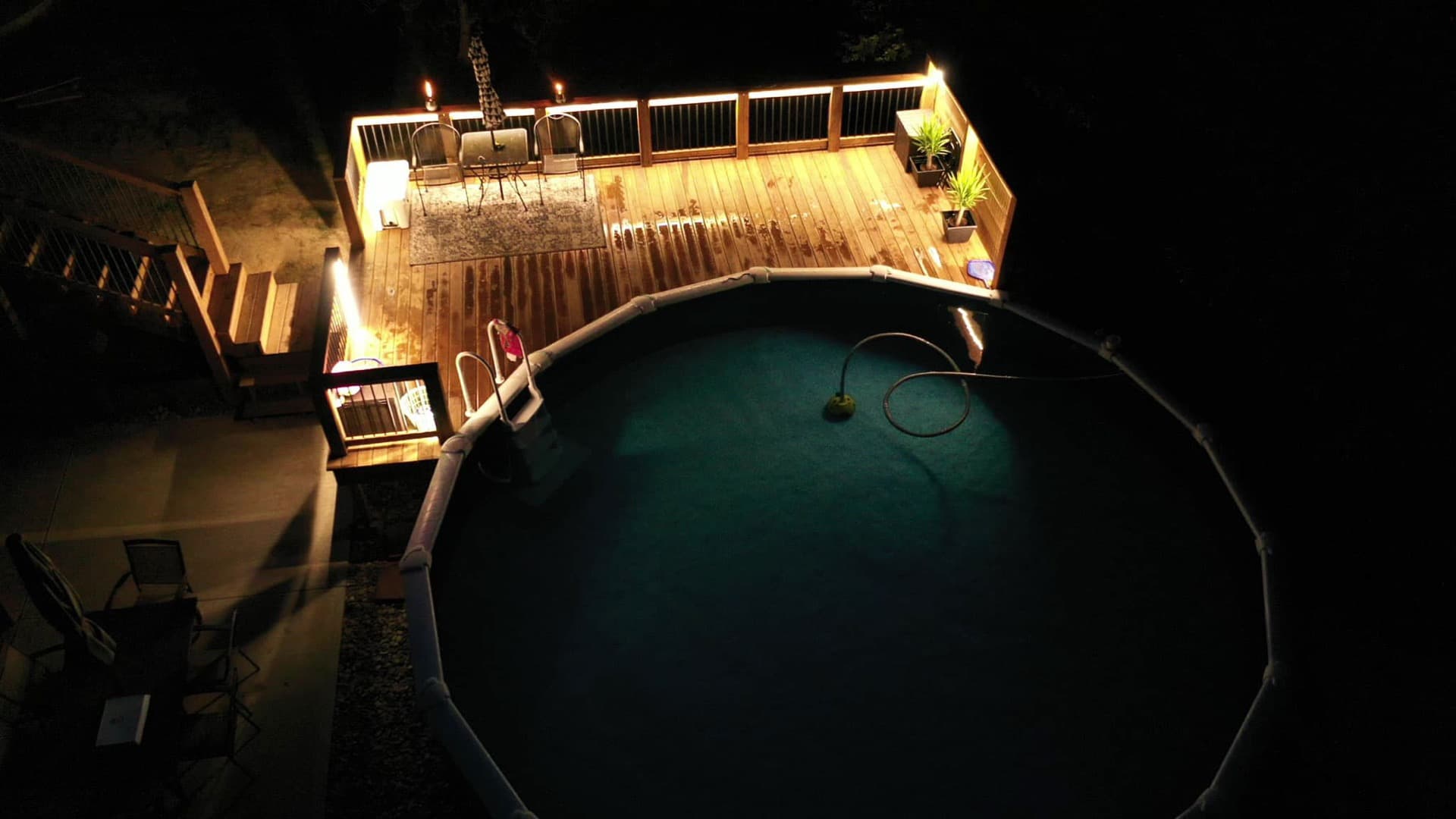 Aerial view of pool deck with railing lights and landscape lighting